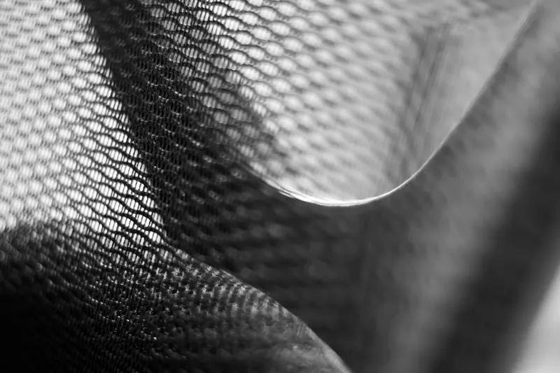 Detailed close-up of black and white mesh fabric showcasing intricate patterns and texture in monochrome