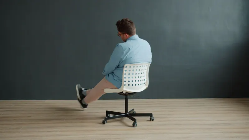 Rear view of a man spinning on a swivel chair in a minimalist interior setting