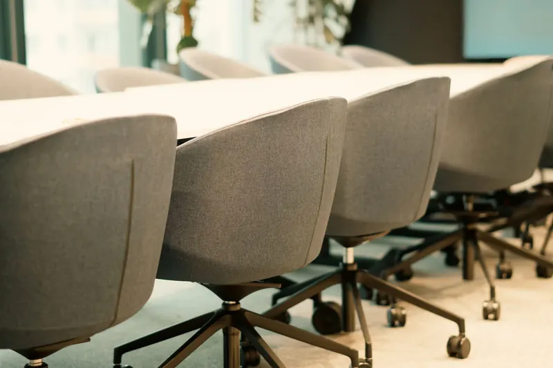 Contemporary conference room featuring a row of empty chairs with soft natural lighting