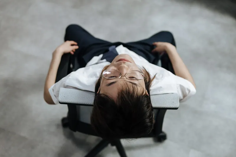 Man in white shirt and glasses reclining in chair, viewed from above