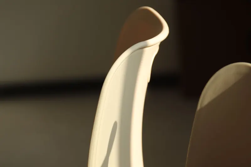 Minimalist chair backrest bathed in warm sunlight in a modern interior setting