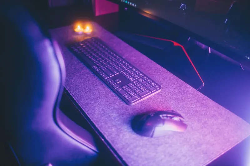 Stylish computer desk setup featuring a keyboard and mouse under ambient lighting