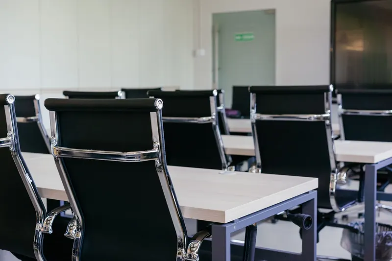 Sleek modern conference room with black chairs and white desks, suitable for business meetings